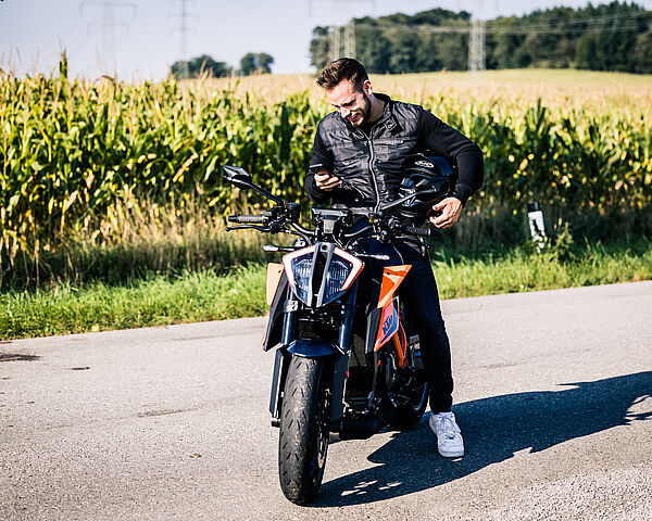 Dunkelhaariger Mann sitzt auf einem Motorrad.