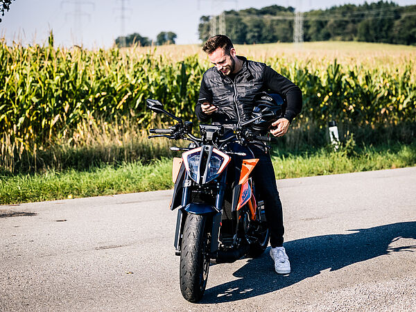 Dunkelhaariger Mann sitzt auf einem Motorrad.